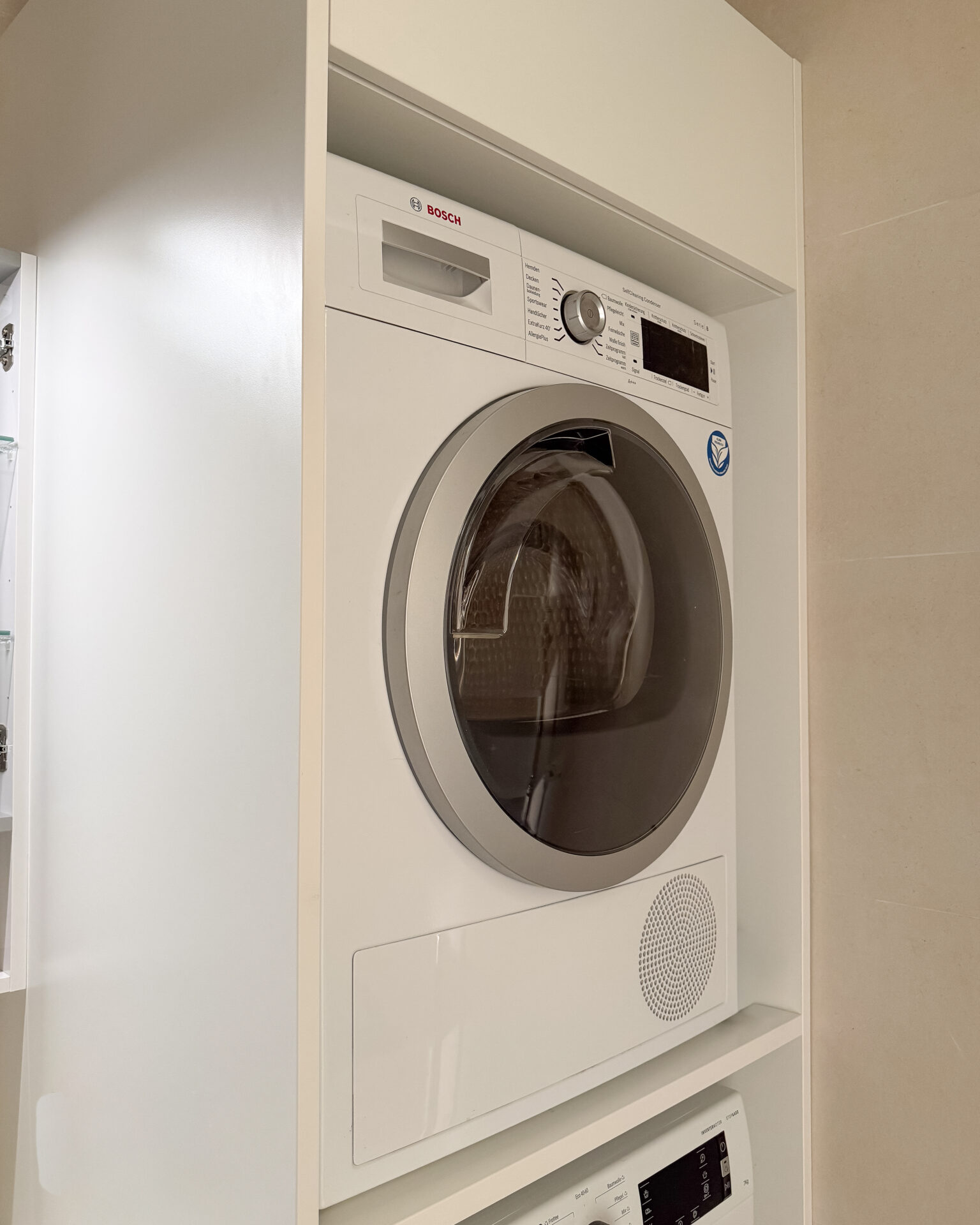 Maßgefertigter Schrank für Waschmaschine und Trockner im Badezimmer – Badmöbel nach Maß in Wien, platzsparend und sauber integriert.