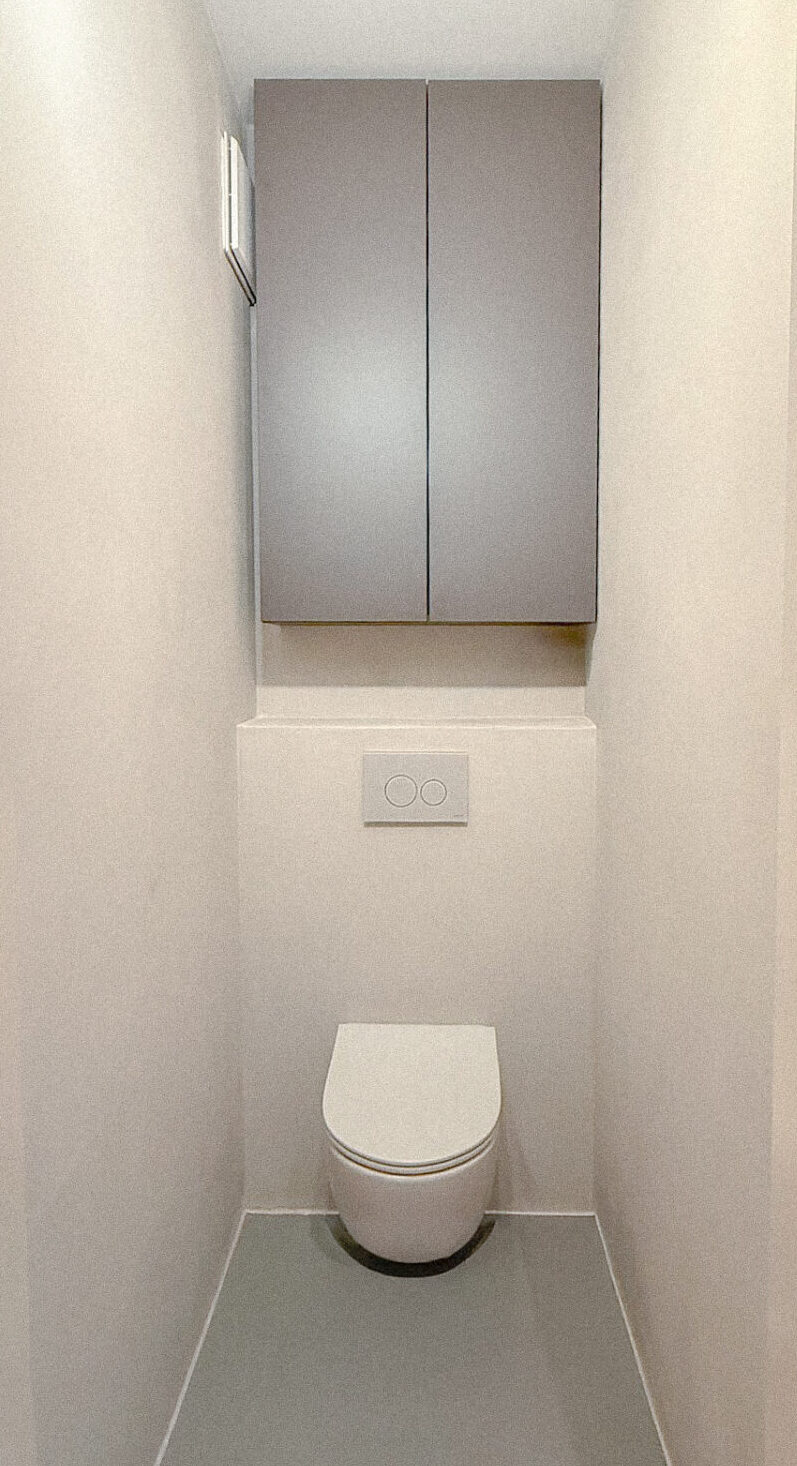 Maßgefertigter Stauraumschrank über dem WC – Badmöbel nach Maß in Wien für optimal genutzten Stauraum im Badezimmer.